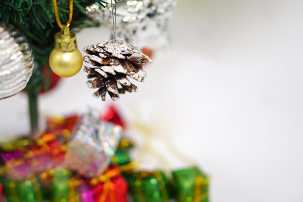 Kerstboom met versierd item dat in een boom hangt en een geschenkdoos onder de kerstboom. prettige kerstdagen, gelukkig nieuwjaar en wenskaartconcept.