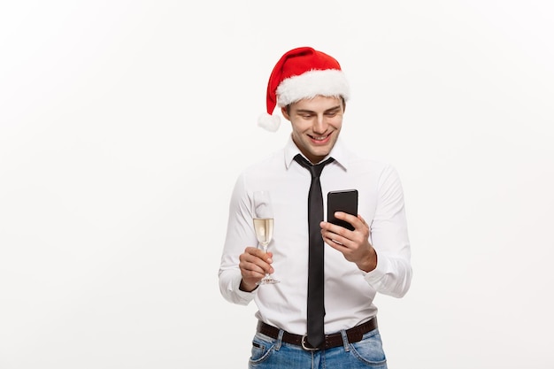 Kerstconcept Knappe zakenman die aan de telefoon praat en een glas champange vasthoudt om Kerstmis en Nieuwjaar te vieren