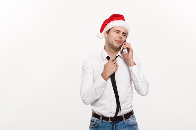 Kerstconcept Stressvolle knappe zakenman die op eerste kerstdag serieus aan de telefoon praat
