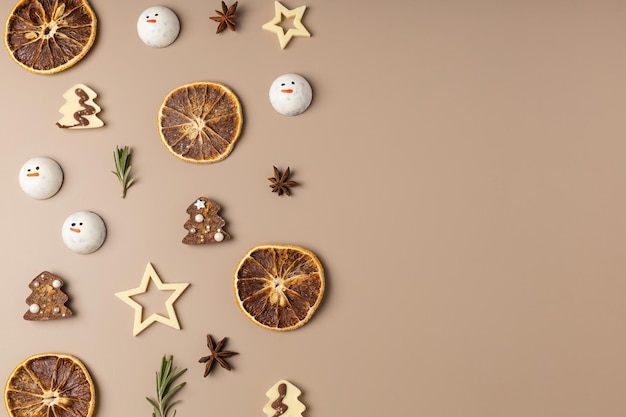 Kerstdecor van gedroogde sinaasappelen, sterren, chocolade, rozemarijn op een beige achtergrond