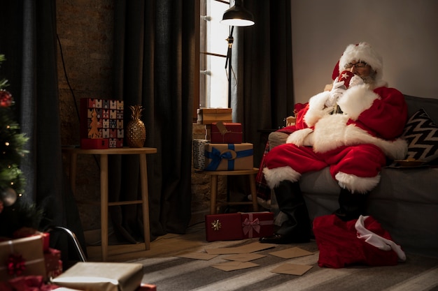 Gratis foto kerstman die een kopje koffie drinkt