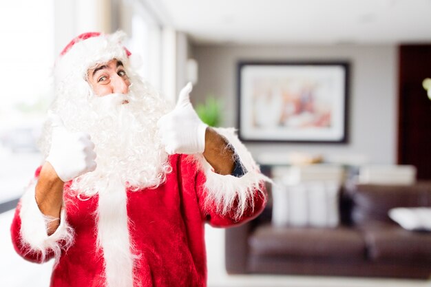 Kerstman in een huis met thumbs up