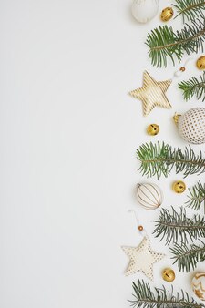 Kerstmis of nieuwjaar samenstelling. rand gemaakt van sparren takken en gouden versieringen op witte achtergrond. plat lag, bovenaanzicht, kopieer ruimte.