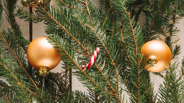 Kerstmisachtergrond met gouden ballen en suikergoedriet