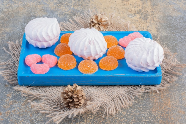 Kerstmiszephyr met geleisuikergoed op een blauw bord. Hoge kwaliteit foto