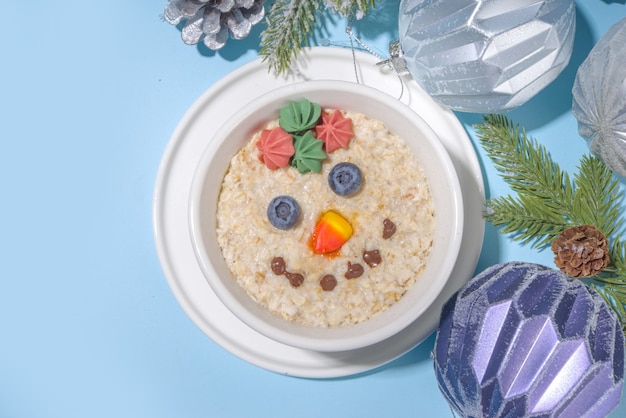 Kerstochtendontbijt - havermoutpap versierd als een sneeuwpop, feestelijk eten voor kinderen idee Premium Foto
