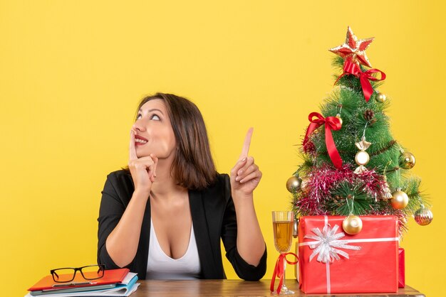 Kerstsfeer met jonge gelukkige bedrijfsdame die van haar succes geniet en benadrukt