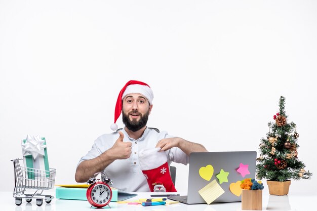 Kerstsfeer met jonge volwassene met kerstmuts en kijkend in kerstsok die een perfect gebaar maakt op kantoor