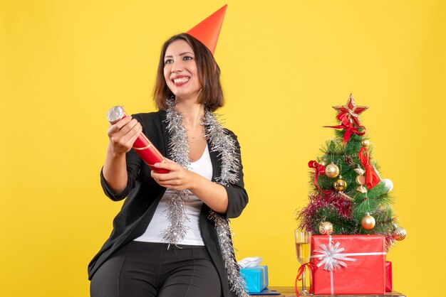 Kerstsfeer met mooie dame die zich gelukkig voelt op kantoor op geel