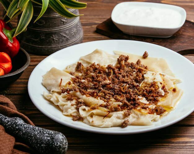 Khinkali in de vorm van bladeren met gevulde vlees en gebakken uien op tafel