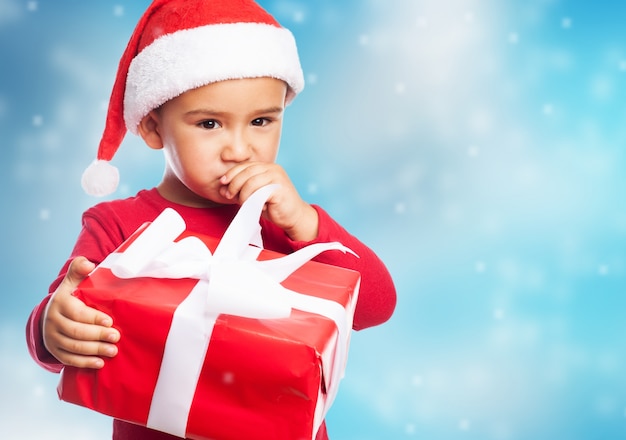 Kid denken met een geschenk in zijn hand