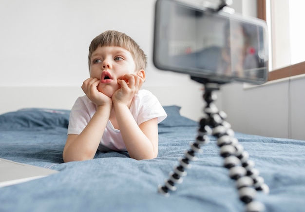 Gratis foto kid in bed met smartphone