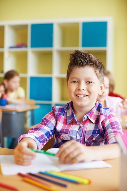 Kid lachend met een groene potlood