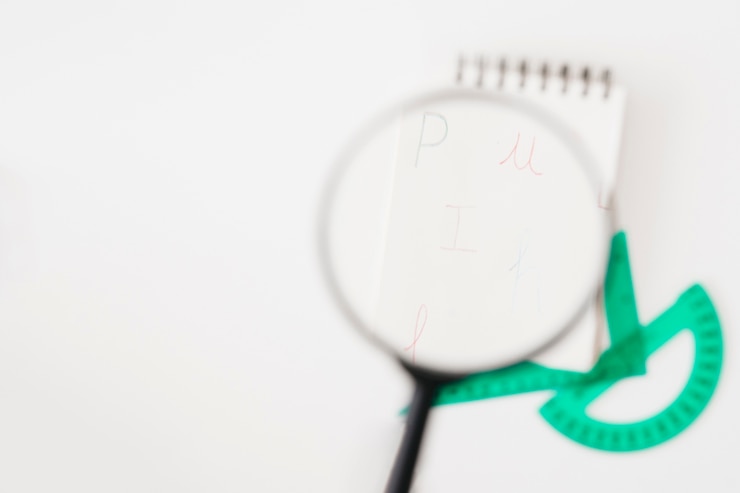Gratis Foto kijkend door vergrootglas op notitieblok
