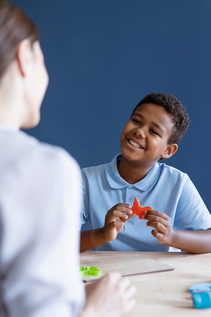 Kind doet een ergotherapiesessie met een psycholoog