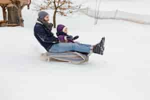 Gratis foto kind geniet van winteractiviteiten met hun gezin