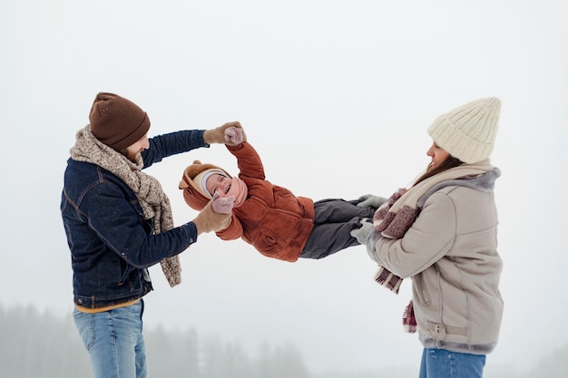 Kind geniet van winteractiviteiten met hun gezin