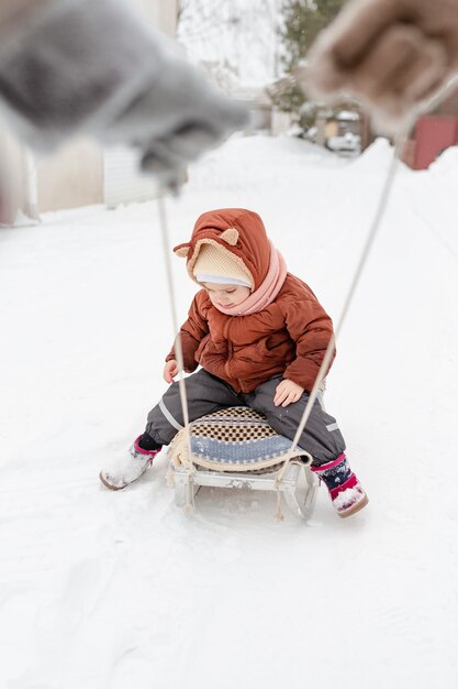 Kind geniet van winteractiviteiten met hun gezin