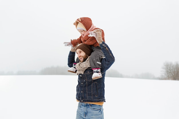 Gratis foto kind geniet van winteractiviteiten met hun gezin