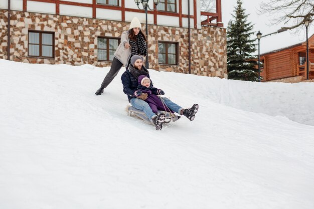 Kind geniet van winteractiviteiten met hun gezin