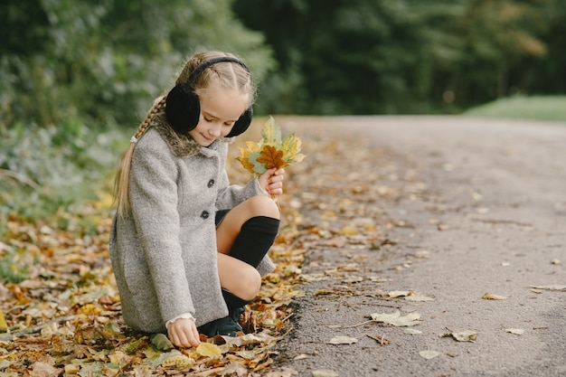 Kind in een herfstpark. kid in een grijze jas.