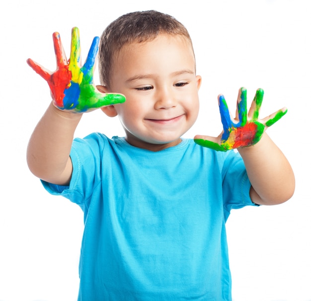 Kind lacht met de handen vol verf
