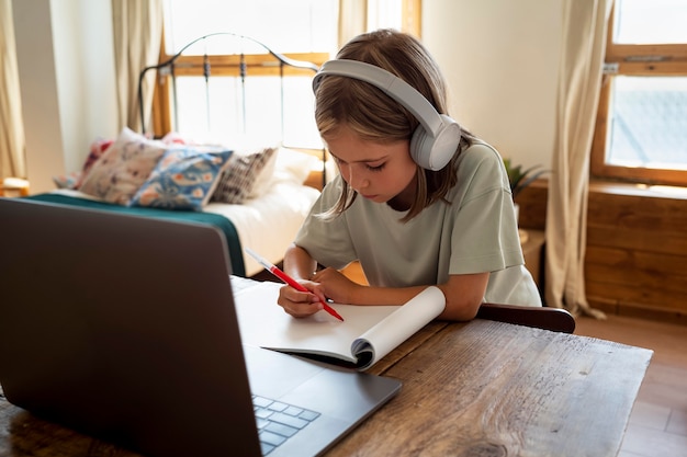 Gratis foto kind studeert aan bureau medium shot