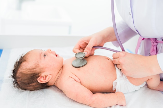 Kinderarts arts onderzoekt babymeisje met stethoscoop