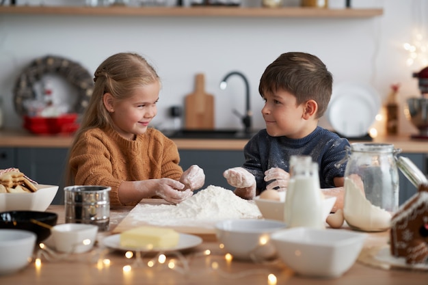 Kinderen bereiden gebak voor kerstkoekjes