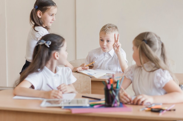 Kinderen bespreken op bureaus in de klas