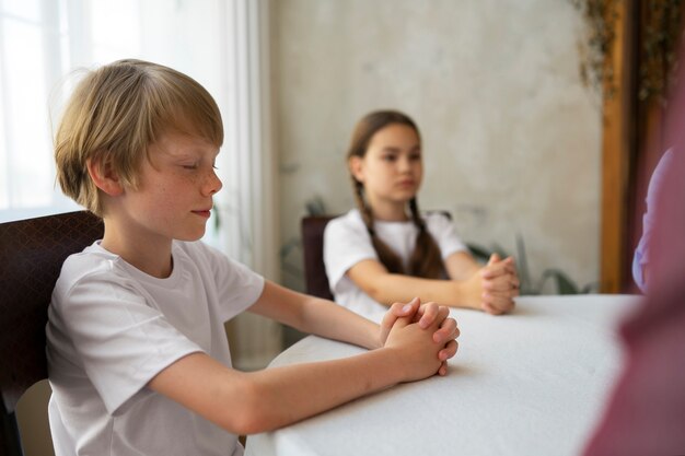 Kinderen bidden samen zijaanzicht