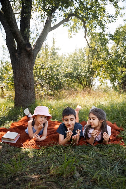 Kinderen brengen samen tijd buiten op deken door, genietend van hun kindertijd