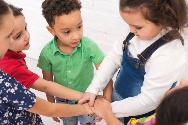 Kinderen die hand in groep houden