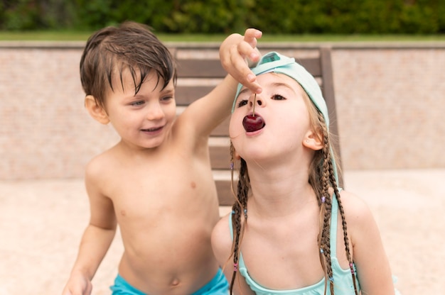 Kinderen die kersen eten bij pool