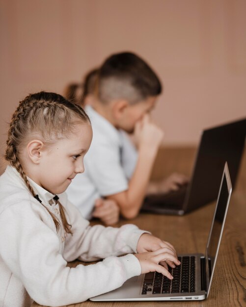 Kinderen die laptops binnenshuis gebruiken