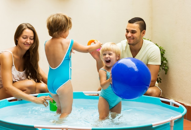 Kinderen en ouders die in pool spelen