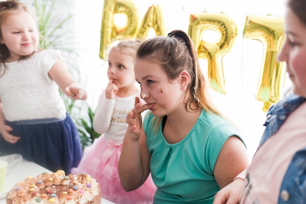 Kinderen en tiener proevende cake