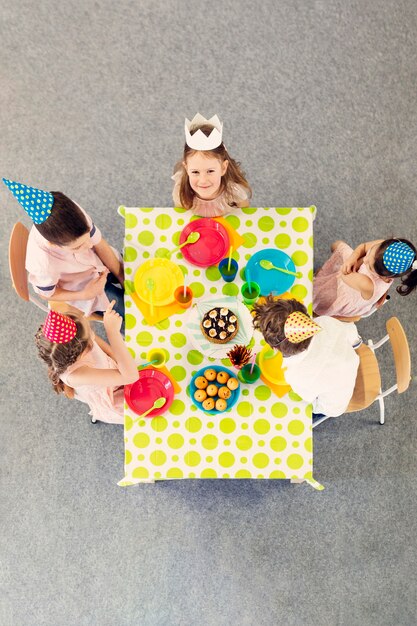 Gratis foto kinderen feest aan de gekleurde tafel