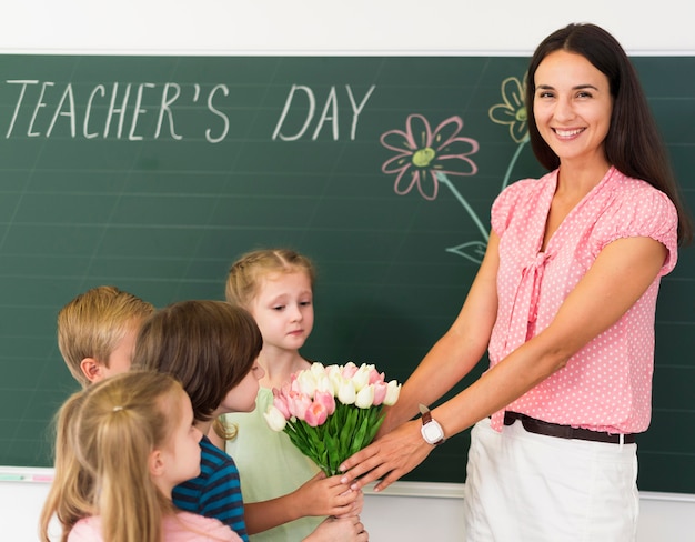 Kinderen geven bloemen aan hun leraar