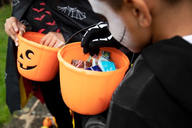 Kinderen houden hun trick or treat-emmers vast