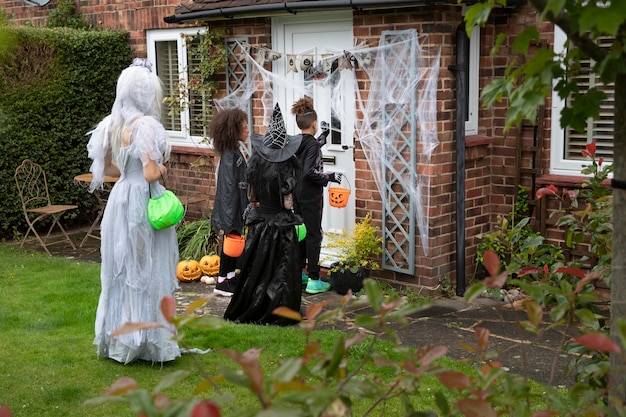 Gratis foto kinderen in kostuums trick or treat bij iemand thuis