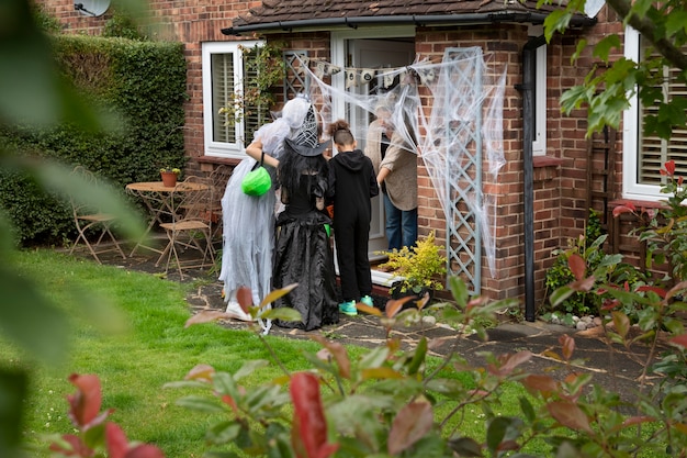 Kinderen in kostuums trick or treat bij iemand thuis