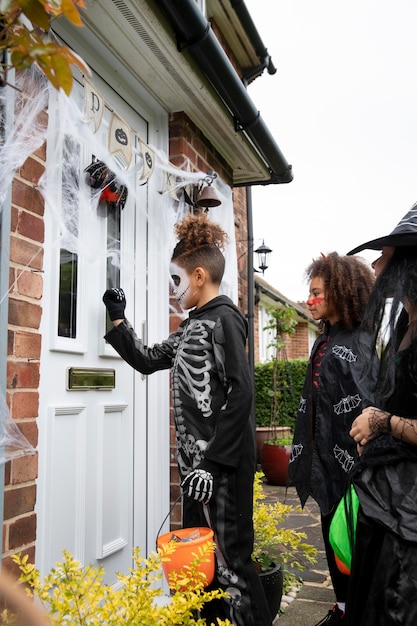 Gratis foto kinderen in kostuums trick or treat bij iemand thuis