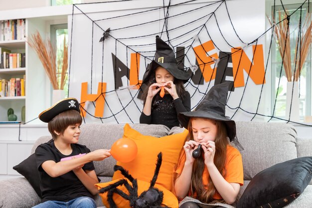 Kinderen, jongen en meisjes blazen een ballon om Halloween-feestdecoratie voor te bereiden