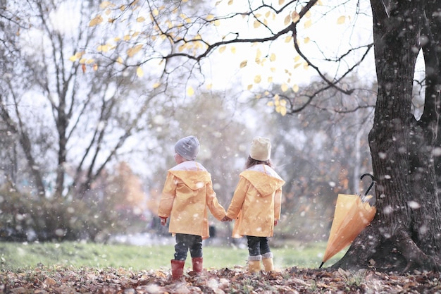 Kinderen lopen in het park met de eerste sneeuw