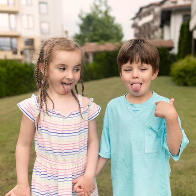 Gratis foto kinderen met tong uit terwijl hand in hand