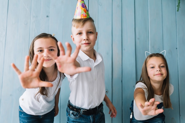 Gratis foto kinderen proberen camera te bereiken op verjaardagsfeestje