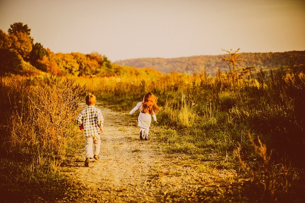 Kinderen rennen over een herfstveld