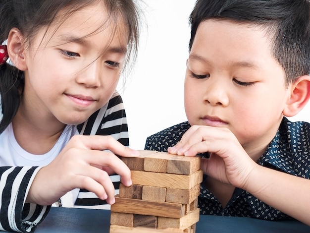 Kinderen spelen jenga, een houten blokken torenspel