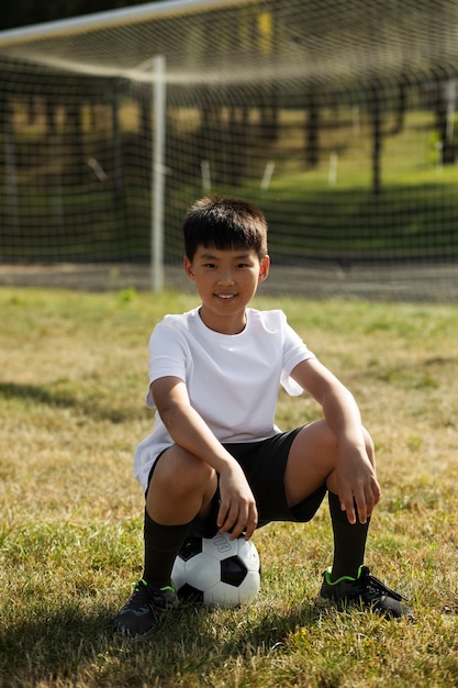 Gratis foto kinderen voetballen onder toezicht van voetbaltrainer